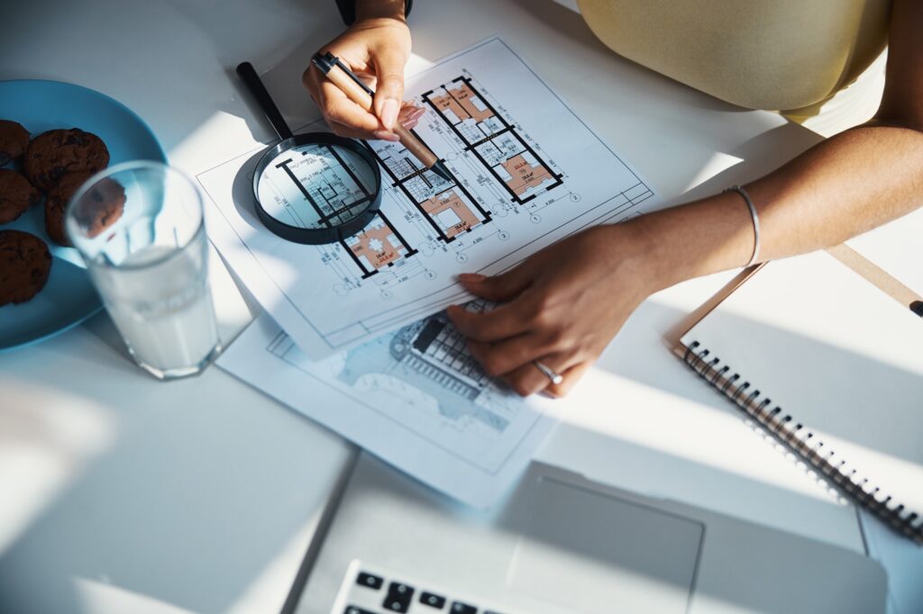 Female architect studying building plan at home